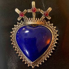 This Exquisite Pendant Features A Beautiful Lapis Lazuli Heart, A Stone Known For Its Deep Blue Color And Calming Energy. The Heart Is Surrounded By Intricate Silver Filigree Work And Topped With Three Crosses Adorned With Vibrant Garnet Gemstones. This Piece Is Perfect For Adding A Touch Of Spirituality And Elegance To Any Outfit. Key Features: Lapis Lazuli Heart Silver Filigree Work Three Crosses With Garnet Gemstones Dimensions: Approximately 2.5 Inches Tall (Including The Crosses) Artist Stamp: Wanda Lobito Material: Sterling Silver This Unique Pendant Is A Beautiful And Meaningful Piece That Would Make A Wonderful Addition To Any Jewelry Collection. Three Crosses, Deep Blue Color, Lapis Lazuli Pendant, Unique Pendant, Garnet Gemstone, Silver Filigree, Sacred Heart, Accent Colors, Deep Blue