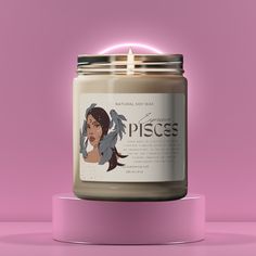 a candle that is sitting on top of a pink stand with an image of a woman's face