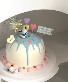 a birthday cake decorated with balloons and confetti