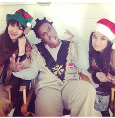 three people sitting in chairs wearing christmas hats