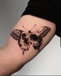 a skull and butterfly tattoo on the arm