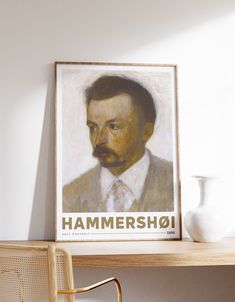 a portrait of a man with a mustache is displayed on a wall above a chair