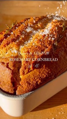 a loaf of rosemary cornbread in a white dish on top of a wooden table