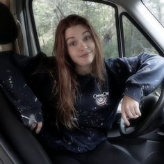 a woman sitting in the driver's seat of a car