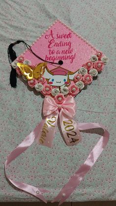 a pink graduation cap with a cow on it's back and ribbon around the neck