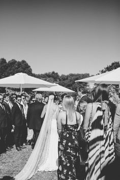 the bride and groom are walking down the aisle at their outdoor wedding in black and white