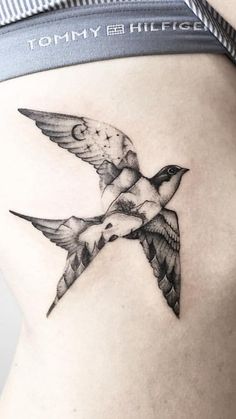 a woman's stomach with a bird tattoo on it