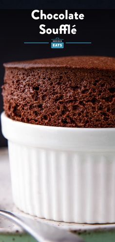 a chocolate souffle cake in a white dish with a fork on the side