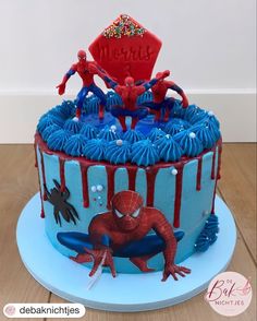 a spiderman birthday cake with blue icing and sprinkles on top