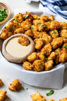 a white bowl filled with tater tots covered in ranch dressing