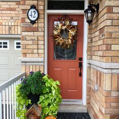 a front porch decorated for fall with pumpkins and greenery