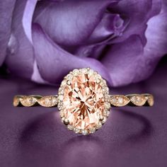 a pink diamond ring sitting on top of a purple flower