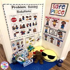 a bulletin board with pictures on it and stuffed animals in front of the door that says problem solver