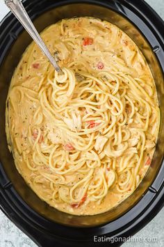 the pasta is being cooked in the crock pot with a spoon and it's ready to be eaten