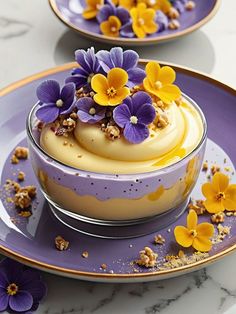 two plates with desserts on them and purple flowers in the bowl next to each other