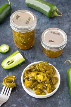 pickled jalapenos in small white bowls with spoons next to them