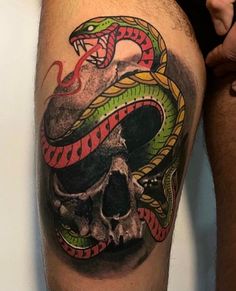 a man with a snake and skull tattoo on his leg