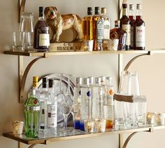 two shelves filled with liquor bottles and glasses on top of eachother's shelf