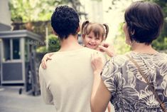 two people are walking down the street with their arms around each other and one person is holding