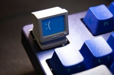 a computer keyboard with a blue and white monitor on it's backlit keys