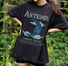 a woman wearing a black t - shirt with the words artems on it