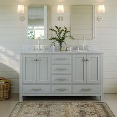 a bathroom with two sinks, mirrors and a rug in front of the sink area