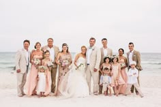 a group of people standing next to each other on a beach