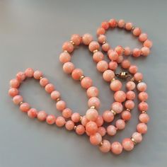 On offer is this very elegant Vintage Italian Peach Pink Coral Necklace featuring large graduating round gems from the sea that are polished to a high gloss and hand knotted with 14 karat yellow gold spacer beads and clasp. Angel Skin coral is one of the largest Mediterranean corals, but still rarely produce beads of this size which graduate from a large 9 mm at the front to 7 mm at the clasp. The necklace has large 5 mm round solid 14k gold spacers at the front to enhance the coral and smaller Elegant Hand-strung Coral Necklace, Elegant Hand-strung Coral Necklaces, Elegant Coral Hand-strung Necklaces, Formal Coral Single Strand Beaded Necklace, Elegant Coral Round Bead Necklaces, Elegant Coral Beaded Necklaces, Classic Round Coral Jewelry, Classic Coral Round Jewelry, Elegant Orange Hand-strung Necklace