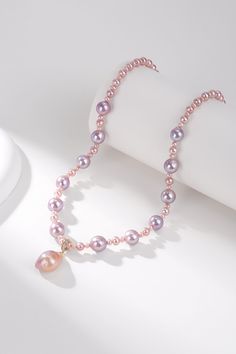 Pink Purple Baroque Freshwater Pearl Necklace with Detachable Pendant Adorn yourself with our Pink Purple Baroque Freshwater Pearl Necklace, featuring a detachable large pendant. This exquisite piece is crafted from varied sizes of Baroque pearls, linked together to form a 43-45cm necklace. At the centerpiece is a stunning 11-13mm Baroque pendant in a vibrant pink-purple hue, which can be removed for versatile styling. The unique shape and dazzling color of the pearls enhance its luxurious appea Elegant Pink Pearl Necklace With Pendant, Pink Pearl Necklace With Pearl Pendant, Pink Pearl Drop Pendant Necklace, Elegant Pink Pearl Pendant Necklace, Elegant Pink Pendant Pearl Necklace, Pink Baroque Pearl Necklace With Pearl Charm, Pink Pearl Necklace With Round Beads And Pendant, Elegant Pink Baroque Pearl Necklace, Pink Baroque Pearl Necklace With Pendant