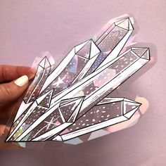 a hand holding up a sticker with crystals on it