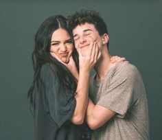 a man and woman posing for the camera with their hands around each other's faces