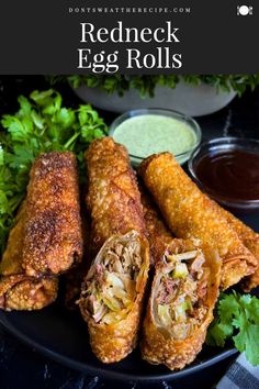 fried egg rolls on a black plate with dipping sauces and parsley in the background