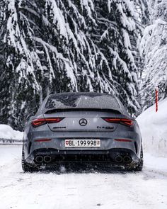 the rear end of a car driving down a snow covered road