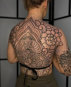 a woman with tattoos on her back and shoulder