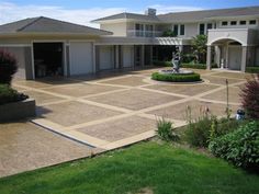 a large house with a fountain in the middle of it's front lawn area