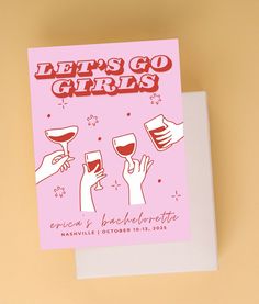 a pink card with the words let's go girls on it and three hands holding wine glasses