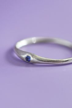 The Siyum gem ring is a true minimalist piece, a fine seamless round band is hand brushed finished allowing a contemporary aesthetic. Perfect for everyday, once you take it off you won't take it off! A petite round blue Sapphire adds a beautiful detail and personalised touch. Use the drop down to select your ring size.If you are unsure of your ring size refer to our size guide. Please select your ring size carefully, and reach out if you have any questions. DetailsSterling Silver Handcrafted in Blue Minimalist Promise Ring, Minimalist Blue Promise Rings, Minimalist Blue Round Band Ring, Minimalist Sapphire Ring With Bezel Setting For Everyday, Minimalist Everyday Birthstone Ring With Round Band, Minimalist Silver Birthstone Ring For Everyday, Minimalist Oval Birthstone Ring For Everyday, Adjustable Minimalist Birthstone Ring With Round Stone, Minimalist Birthstone Ring With Tension Setting