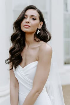 a woman in a white wedding dress posing for the camera