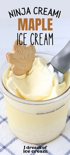 an ice cream in a glass bowl with a spoon and maple leaf on the top