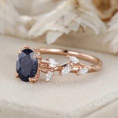 a ring with a blue stone surrounded by white and brown diamonds on top of it