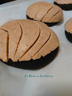 four cookies with peanut butter frosting sitting on top of a white paper wrapper