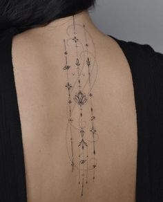 the back of a woman's neck with an intricate tattoo design on her left shoulder