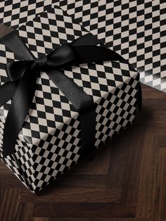 a black and white checkered gift box with a bow on it's side