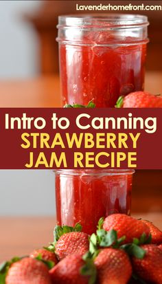 two jars filled with strawberry jam sitting on top of a table next to strawberries