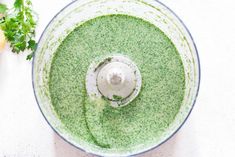 an overhead view of a food processor with pesto in it