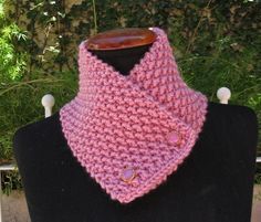 a pink knitted cowl on top of a black mannequin