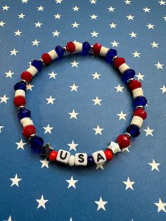 Wear your patriotism with style with this USA beaded stretch bracelet. Tiny silver colored stars on each side of the letter cubes encompass USA. Glass and polymer clay beads in red white and blue display pride of country and flag.  Bracelets are available in a variety of lengths.  Pick your custom length from the drop down menu below.  Please be aware that beading may slightly differ from what is pictured as to accommodate selected sizing.  All our bracelets are made with quality in mind.  With Cheap Blue Beaded Bracelets For 4th Of July, Affordable Handmade Patriotic Bracelets, Patriotic Round Beads Stretch Bracelet For 4th Of July, Patriotic Blue Stretch Bracelet For 4th Of July, Country Bracelets, Usa Bracelet, Crafts Beads, Countries And Flags, Arm Jewelry