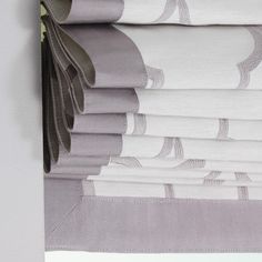 a stack of folded sheets sitting on top of a bed