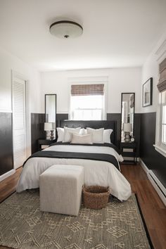 a bedroom with black and white bedding and pillows