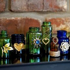 there are many different colored glass jars on the table